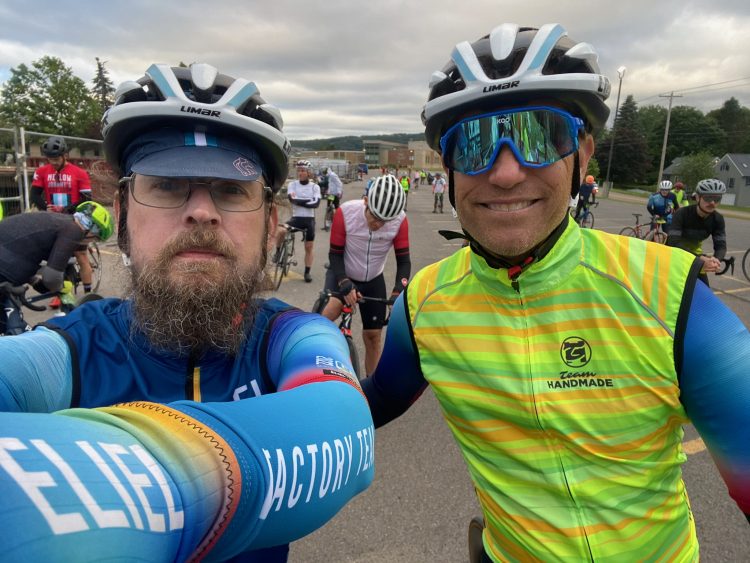 Closeup photo of Nate and Chris with cyclists in the background